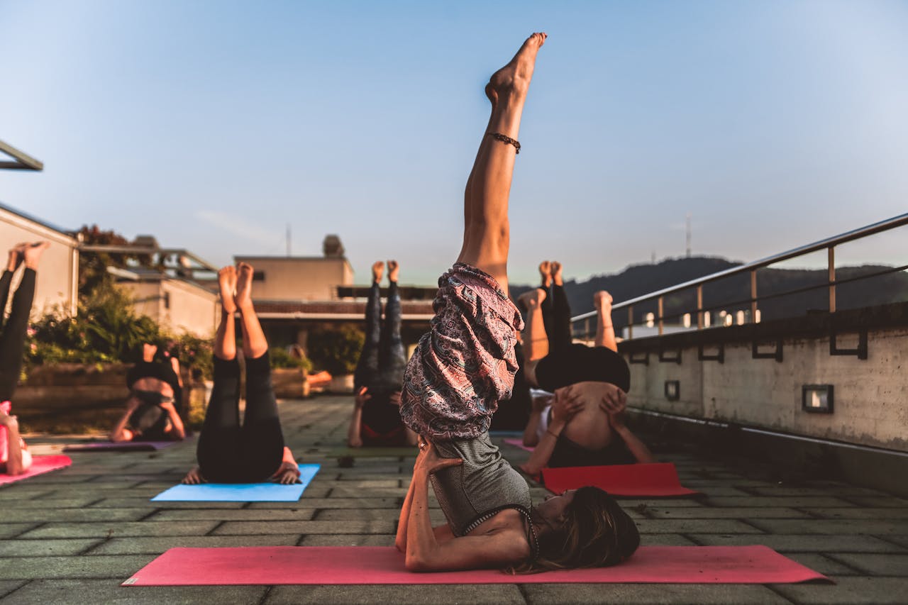 heros-img People practicing yoga on mats outdoors during sunset, focusing on wellness.